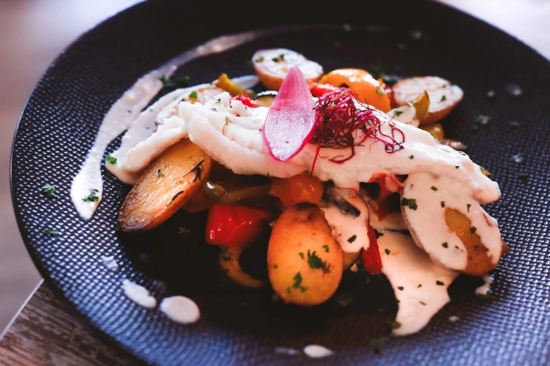 Image plate of baked potatoes, cream and fish